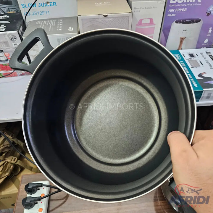 An empty, black, non-stick cooking pot with a handle.