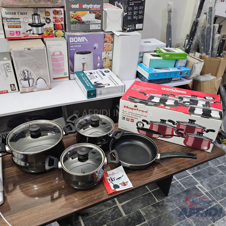 A set of black pots and pans with clear glass lids.