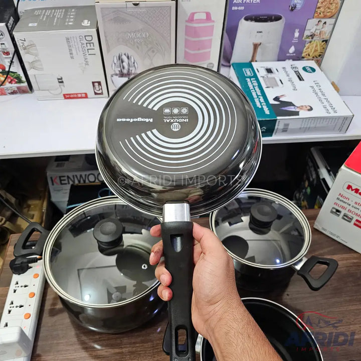 A black frying pan with a detachable handle, featuring a non-stick surface and an induction-compatible base.