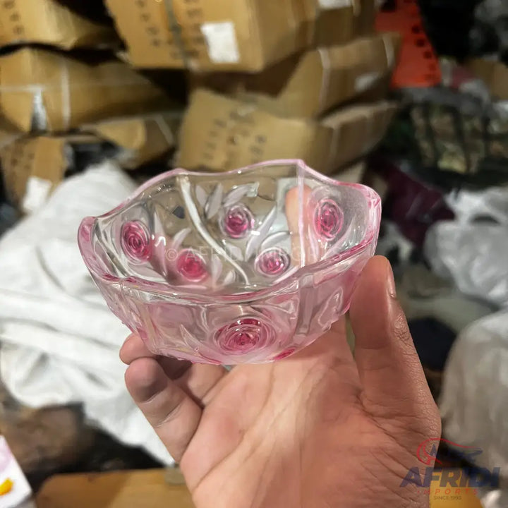A pink glass bowl with a rose pattern.