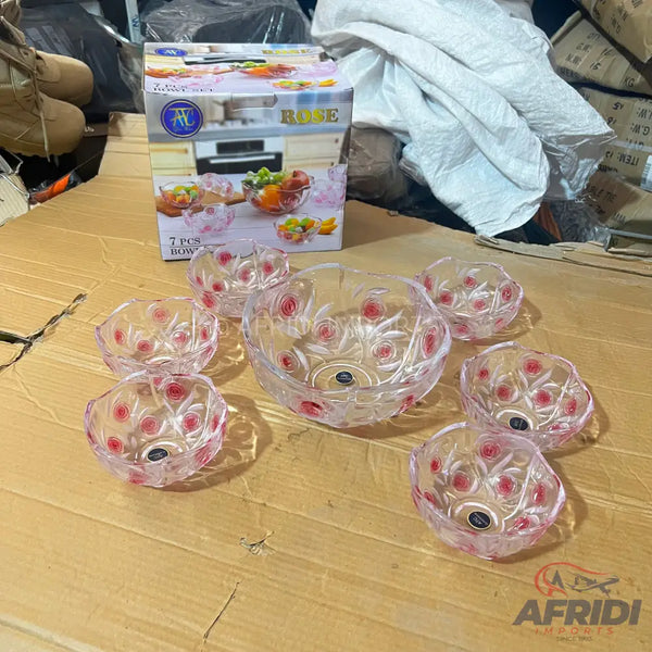 A set of seven clear glass serving bowls with a red floral design.