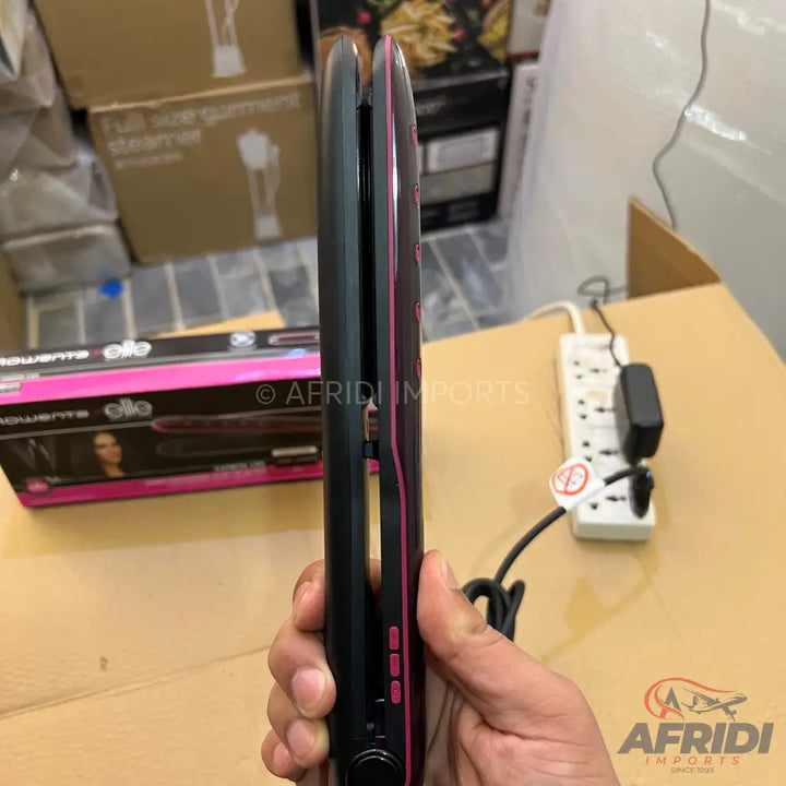 Black hair straightener with pink accents and control buttons.