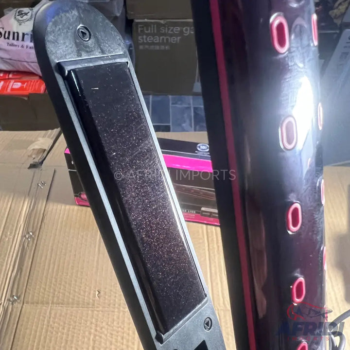 Dark-colored hair straightener with glittery plates and pink accents.
