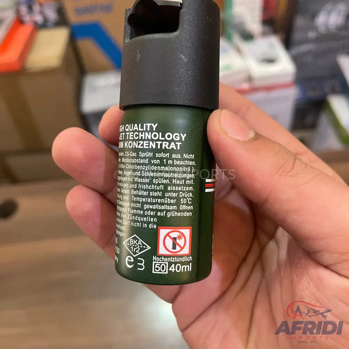 Olive green self-defense spray with a black cap.