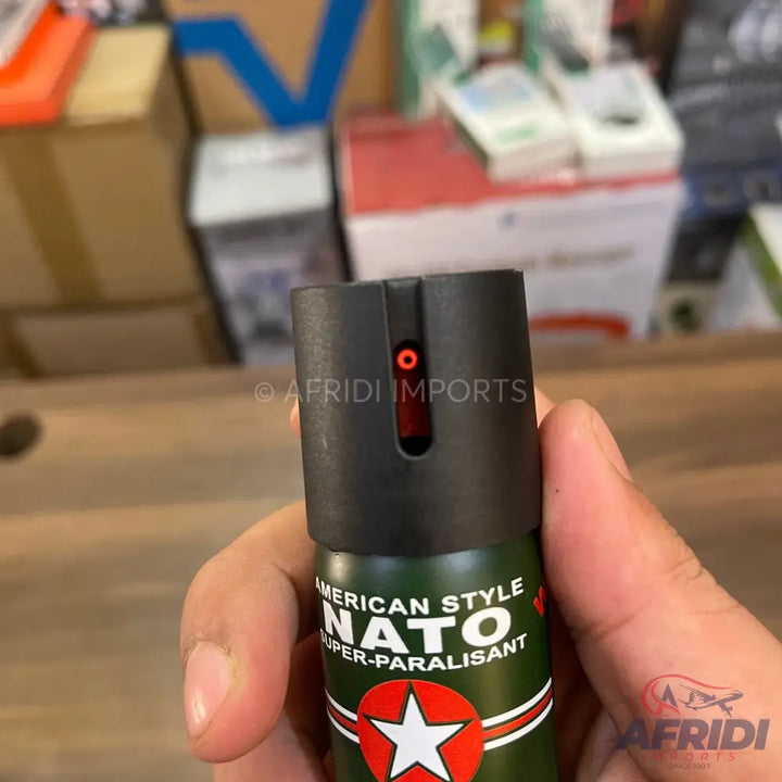 Green and black pepper spray with a red indicator.