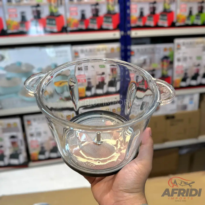 A clear glass food chopper bowl with two handles and a metal base.