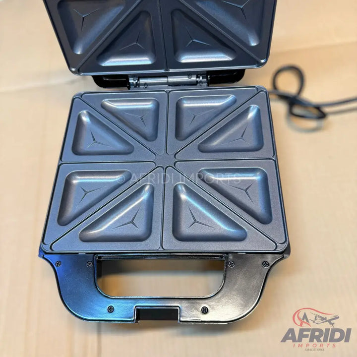 Open electric sandwich maker with non-stick cooking plates for four triangular sandwiches.