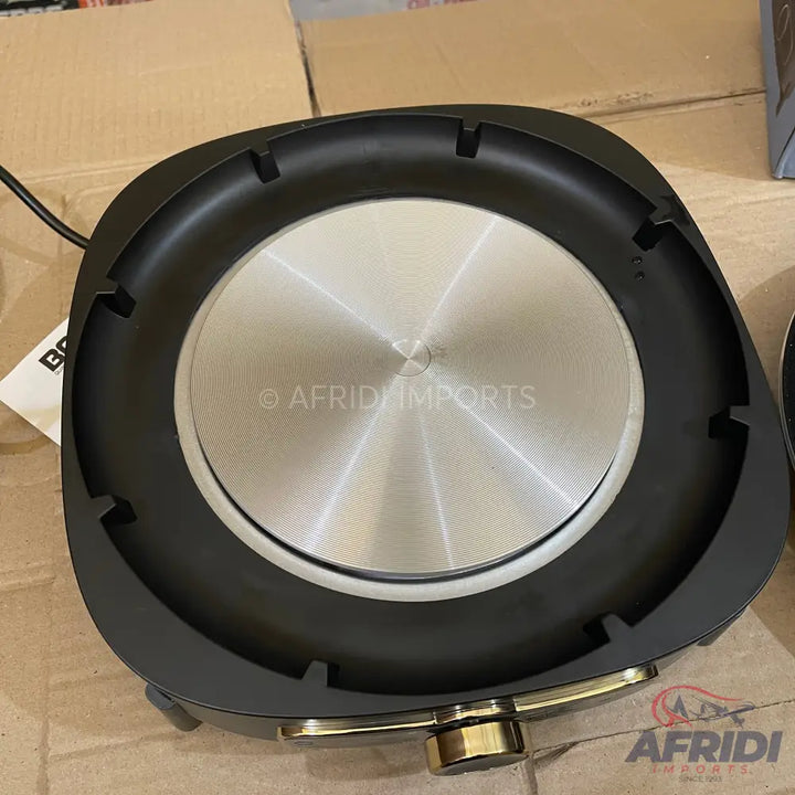 A black, circular induction cooktop with a brushed metal heating surface.
