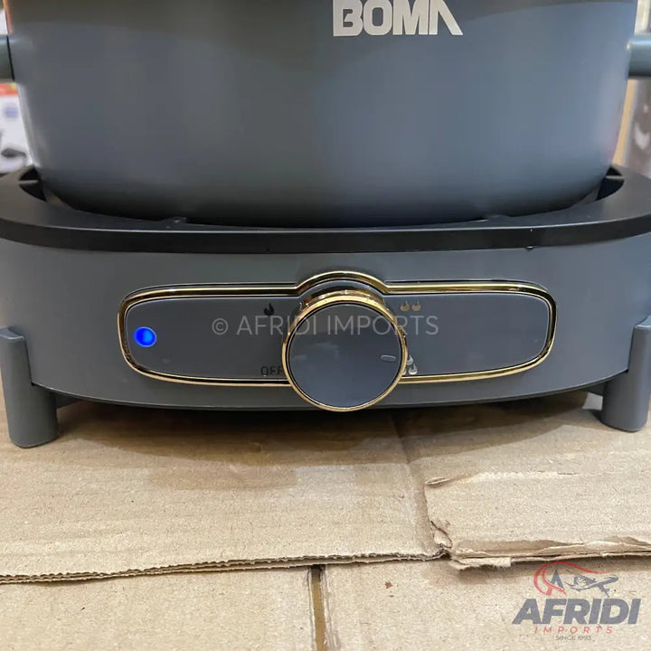 A gray electric cooking pot with a gold-trimmed control panel and a blue indicator light.