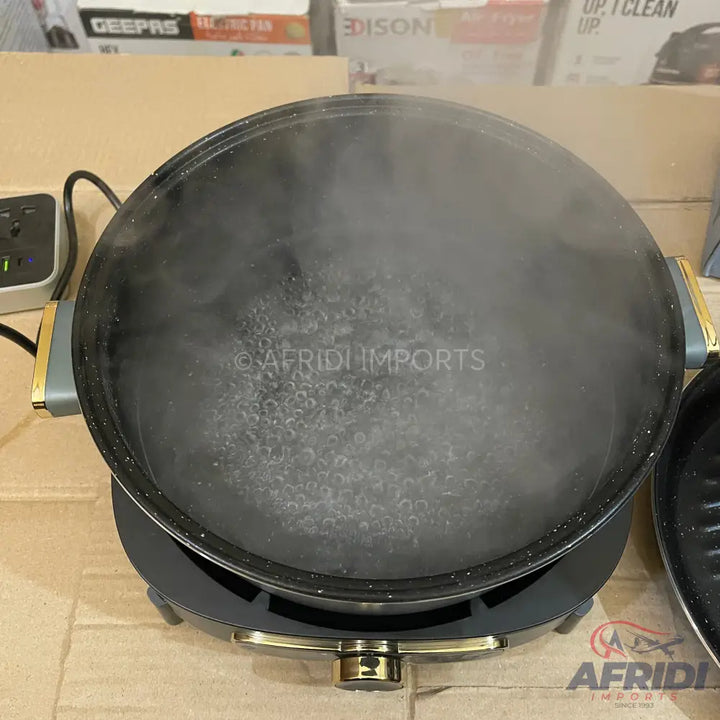 Round black electric griddle with boiling water and steam.