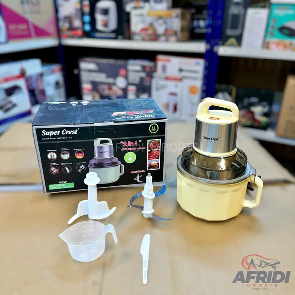 A cream and silver electric food chopper with multiple attachments, including a blade and a whisk.
