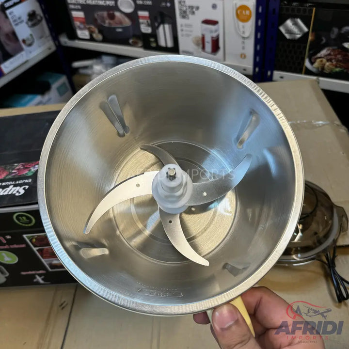A stainless steel food processor bowl with a three-blade assembly.
