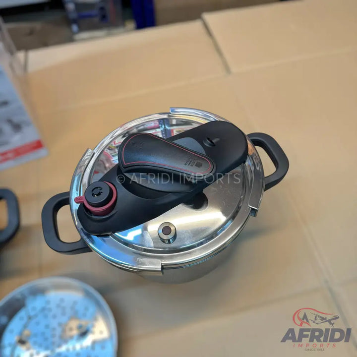 Stainless steel pressure cooker with a black handle and lid mechanism.