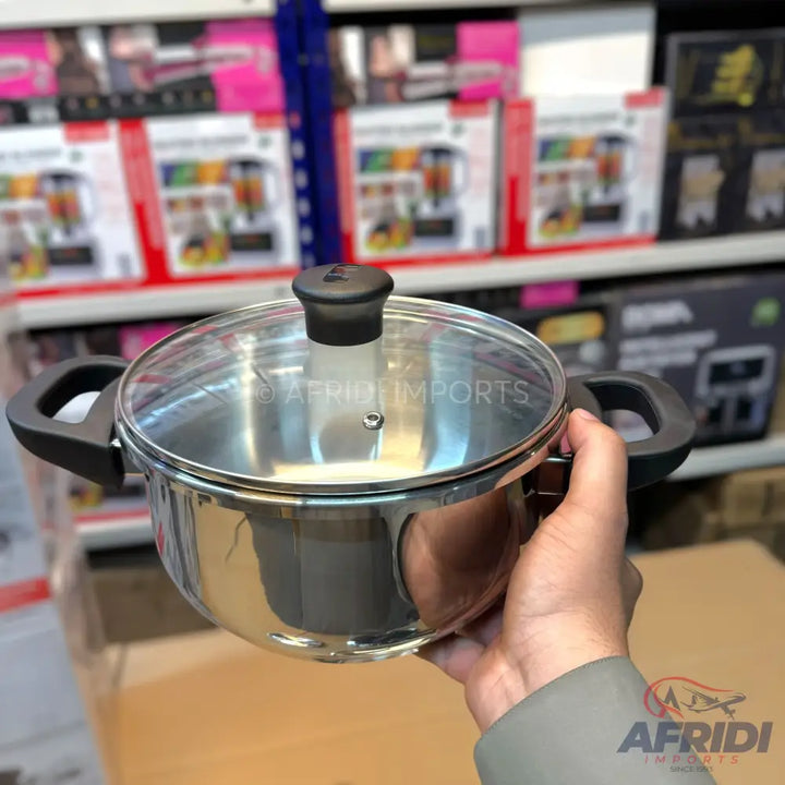 Shiny stainless steel cooking pot with a glass lid and black handles.