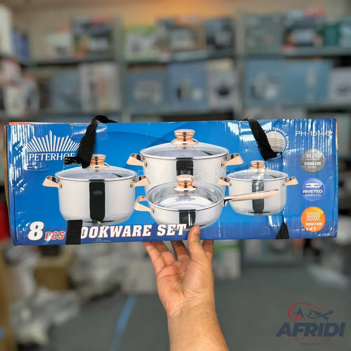 An 8-piece stainless steel cookware set with copper-colored handles and glass lids.