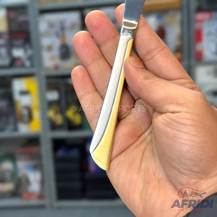 A butter knife with a silver blade and a cream-colored handle.