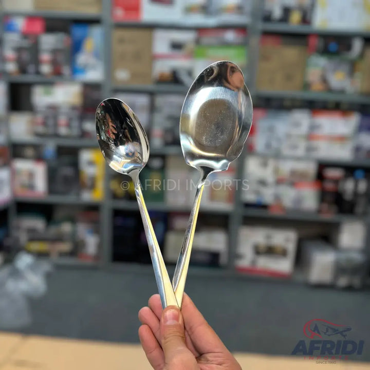 Two shiny, silver-colored metal serving spoons with pointed handles.