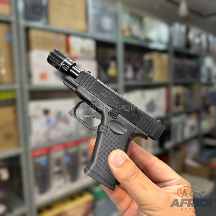 A black semi-automatic pistol with a threaded barrel and an attached compensator.