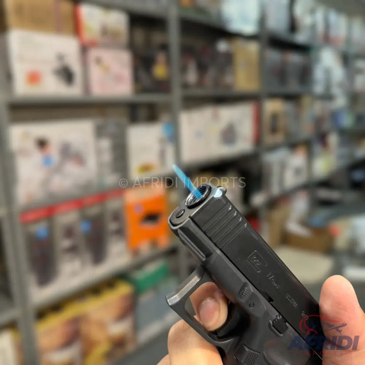 A black, pistol-shaped lighter with a blue flame emerging from the barrel.