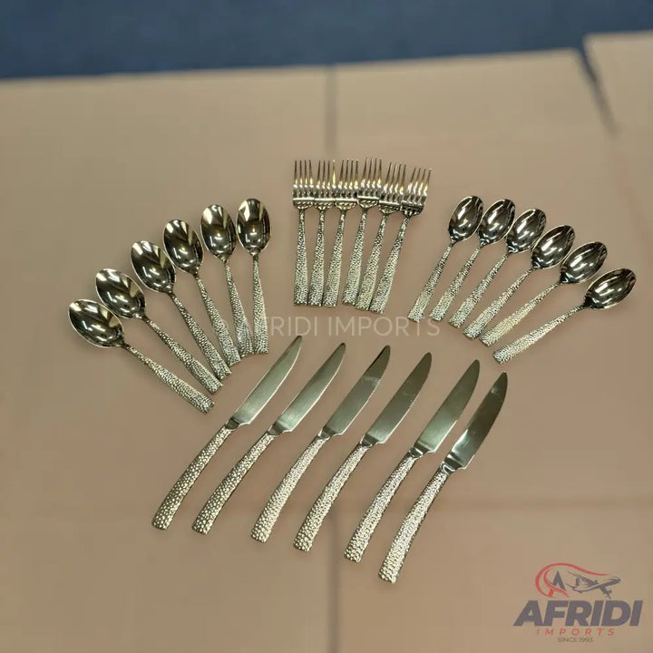 A complete set of hammered-finish silver flatware including spoons, forks, and knives.