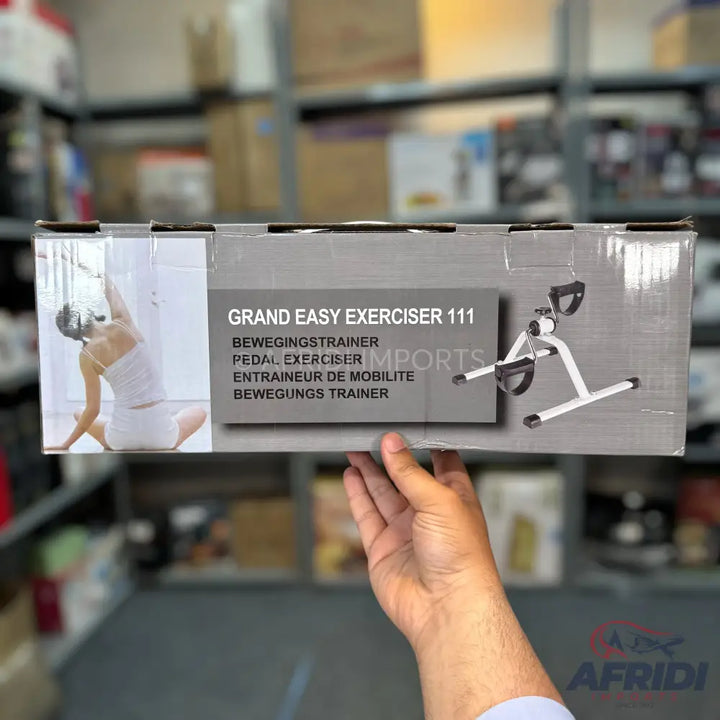 A boxed pedal exerciser with a picture of a person exercising and the product itself.