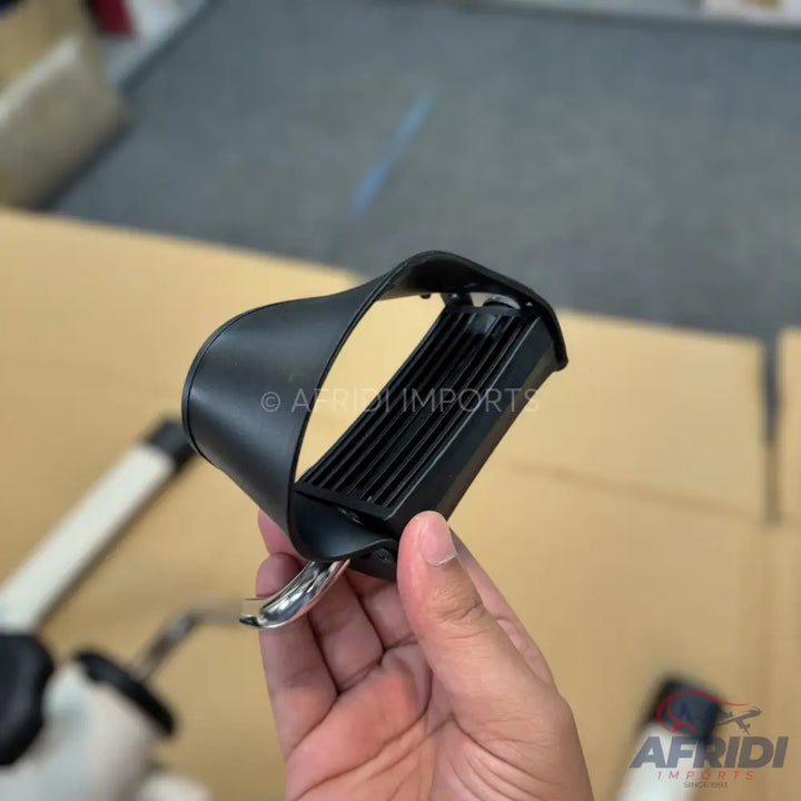 Black exercise bike pedal with a foot strap.