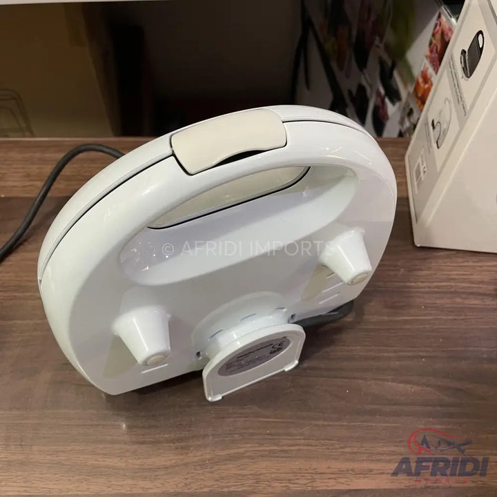 A white electric sandwich maker or waffle iron with a handle and a power cord.