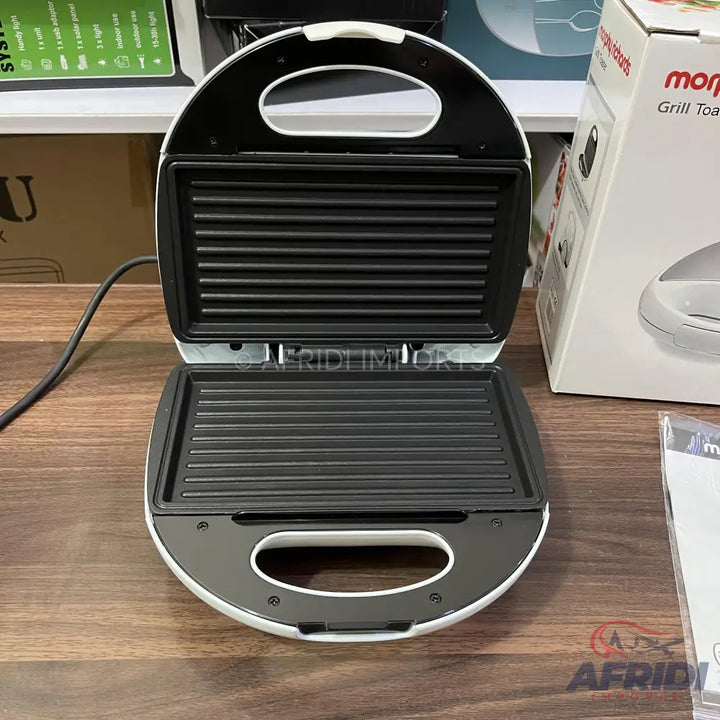 Open white and black electric grill and sandwich maker.