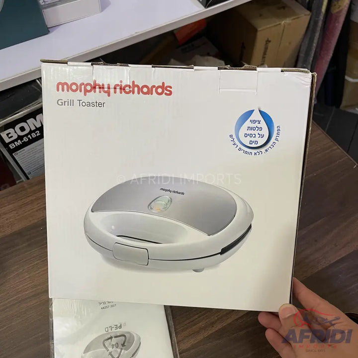 A packaged Morphy Richards grill toaster in a white box, featuring a non-stick coating and a silver and white design.