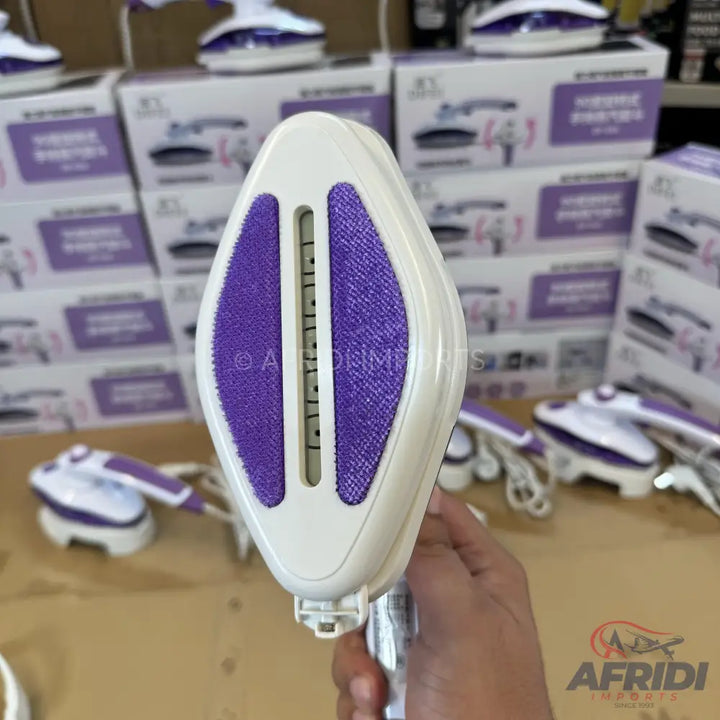 A handheld garment steamer with a white body and purple fabric lint brush.
