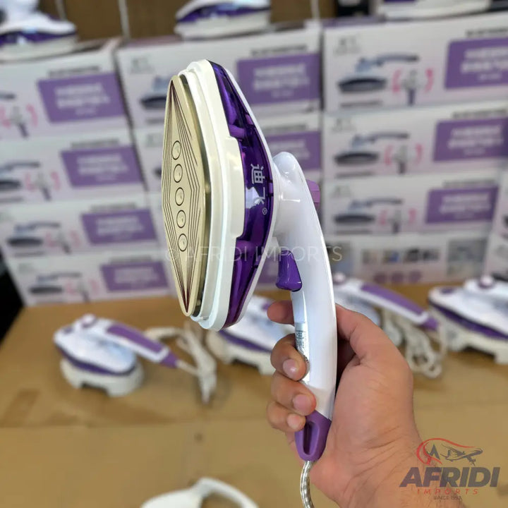 Handheld purple and white steam iron.