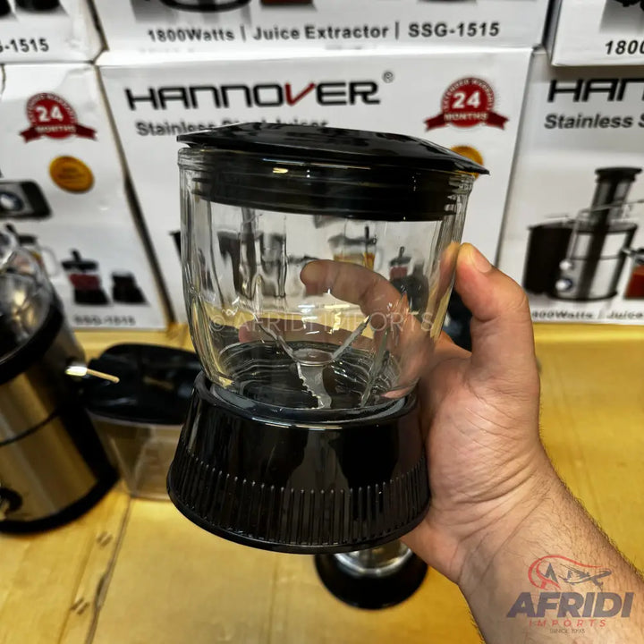 A clear glass blender jar with a black base and lid, containing a blade assembly.