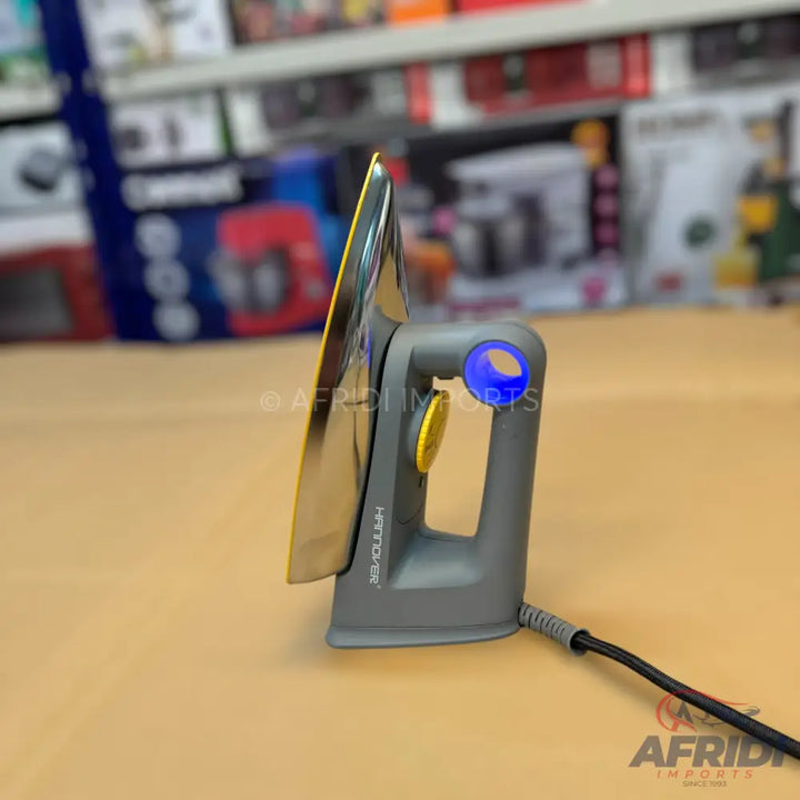Grey electric iron with a reflective soleplate and a blue indicator light.