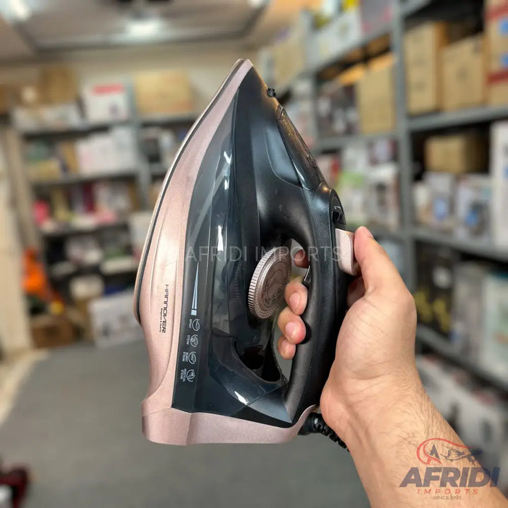 A black and rose gold steam iron with a water reservoir window.