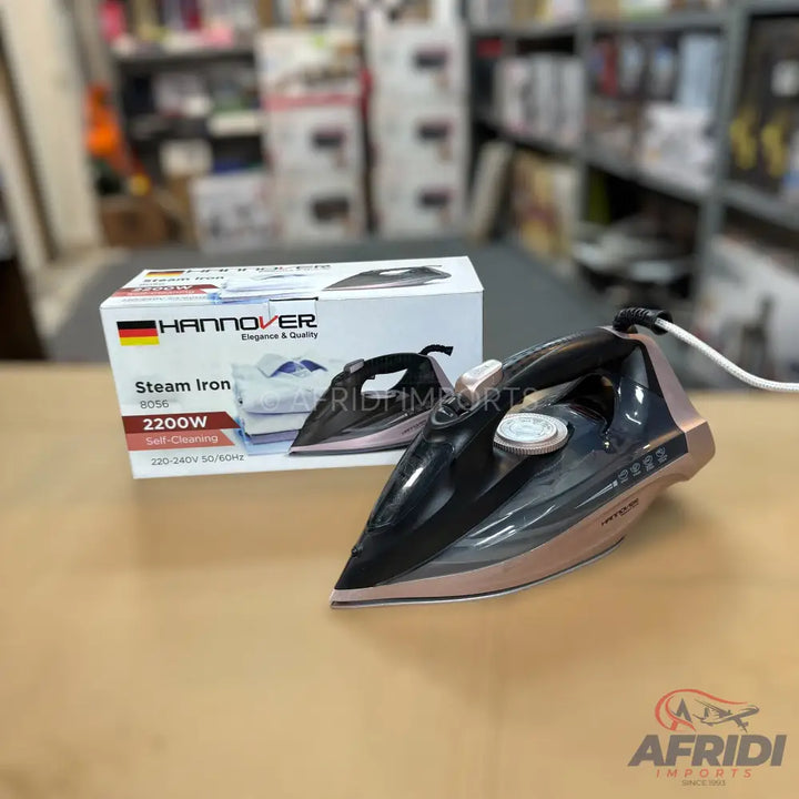 A black and rose gold steam iron with a white power cord.