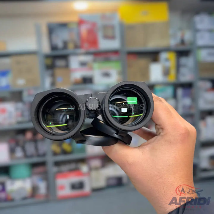 Black binoculars with green-coated lenses and an internal reticle.