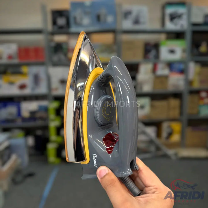 A dark grey and chrome electric dry iron with a yellow trim, temperature dial, and red indicator light.