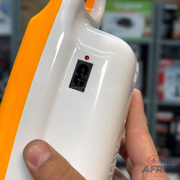 A white and orange portable device with a red indicator light and two black circular openings.