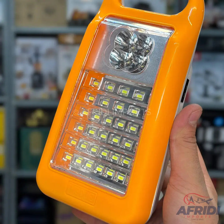 An orange portable LED lantern with multiple light settings.
