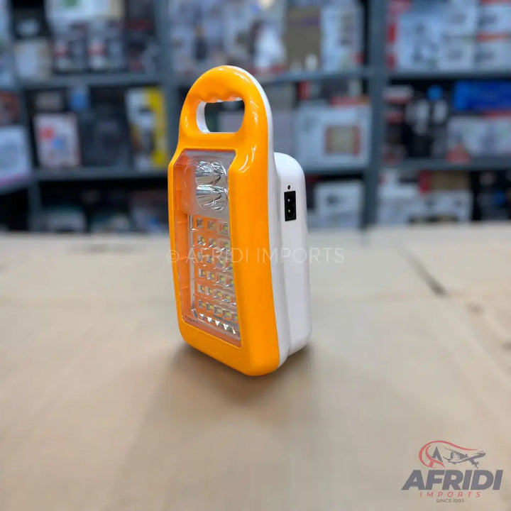 Portable solar-powered LED lantern with a bright orange handle and a white body.