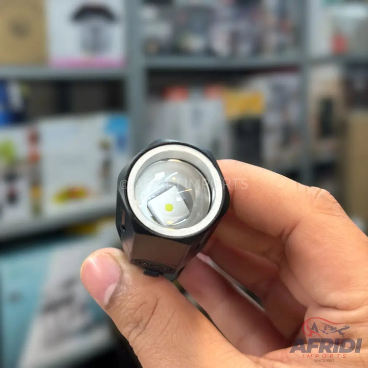 A close-up view of the illuminated LED bulb of a black flashlight.