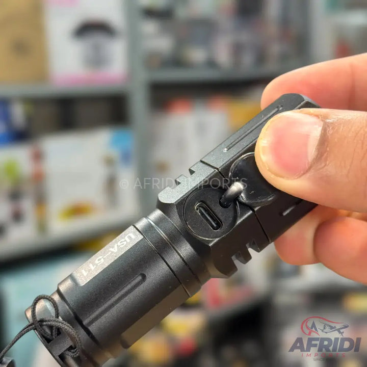 Black tactical flashlight with a USB-C charging port and a lanyard.
