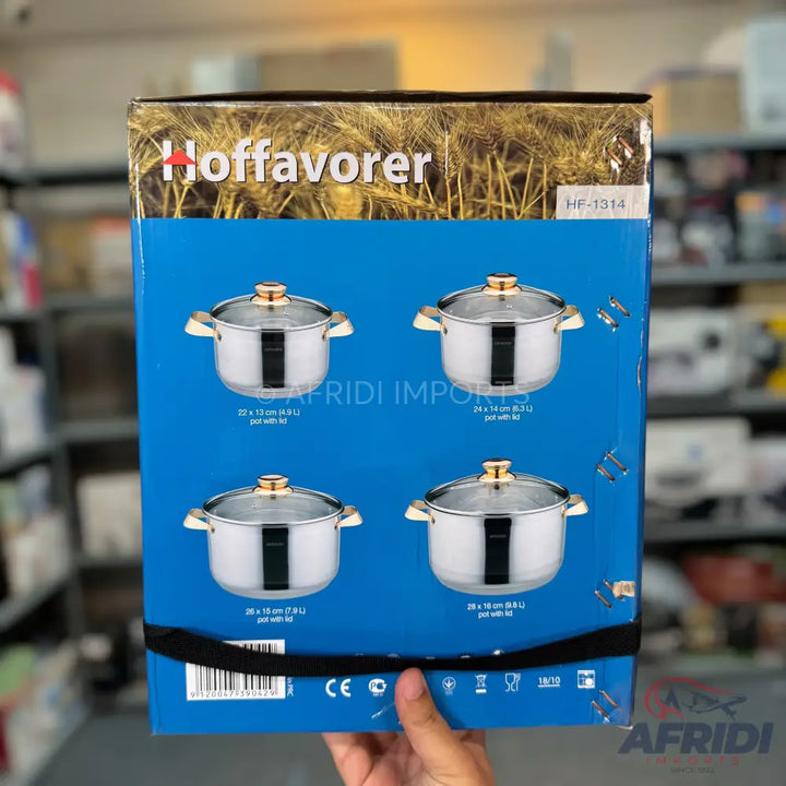 A set of four stainless steel cooking pots with glass lids.
