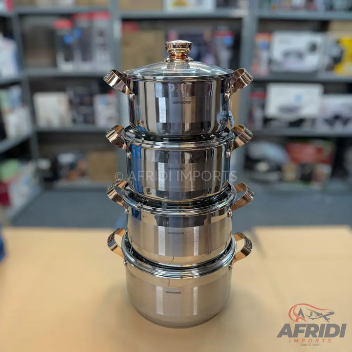A stack of four stainless steel cooking pots with lids and gold-colored handles.