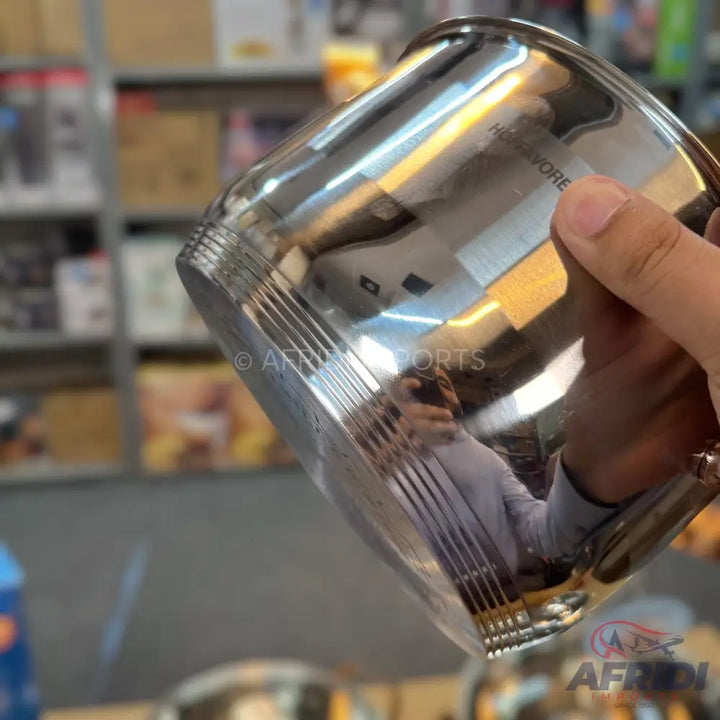 A shiny, metallic, stainless steel cup with a ribbed pattern near the base.