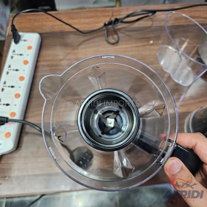 Transparent plastic blender jar with a four-blade assembly.