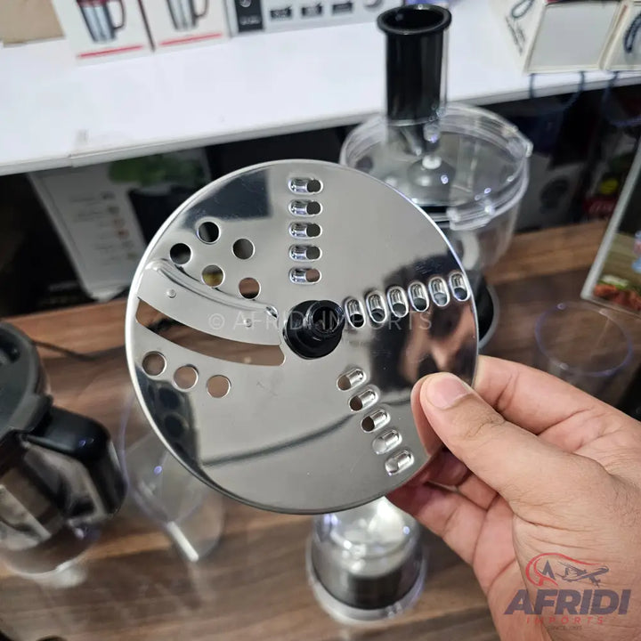 A shiny, silver, multi-functional food processor blade with various grating and slicing holes.
