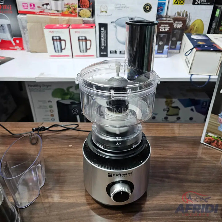 A silver and black food processor with a clear bowl and lid.
