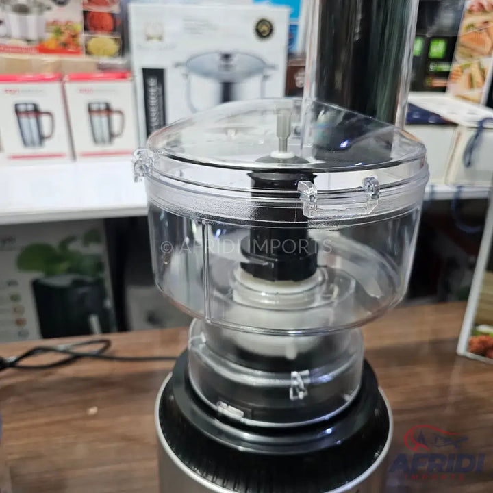 A transparent food processor work bowl and lid assembly, with a black central post for attachments, designed for kitchen food preparation.