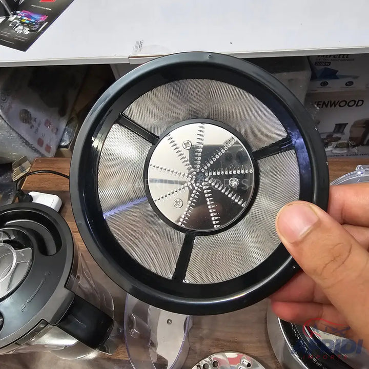 A circular juicer filter with a central grater and mesh screen.